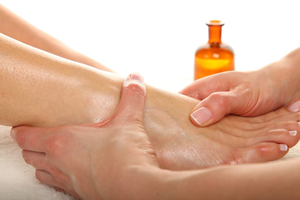 Person massaging another's foot and ankle with oil